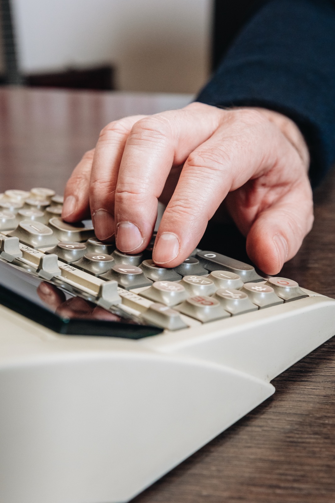 Hände auf der Tastatur einer Rechenmaschine